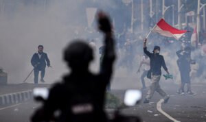 Massa aksi penolak UU Cipta Kerja mengibarkan bendera Merah-Putih di Tugu Tani, Jakarta Pusat, Selasa (13/10/2020).